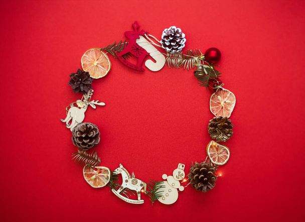 Chirstmas wreath decoration. Flat lay, top view. Red background. - Photo, Image