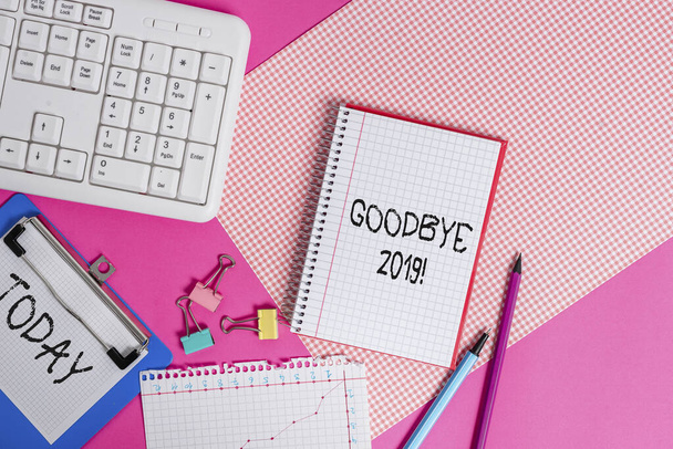 A Good Bye 2019-et bemutató írásos feljegyzés. Üzleti fotó bemutatása fejezi ki jókívánságait búcsúzáskor vagy a tavalyi év végén A színes sima asztal fölé helyezett íróberendezések és számítógépes tárgyak írása. - Fotó, kép