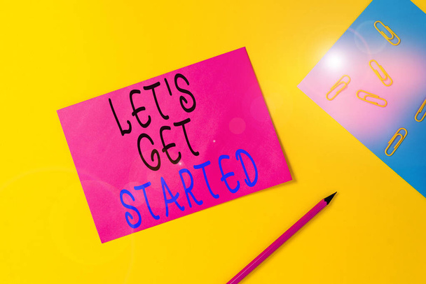 Escribiendo nota mostrando Let S Is Get Started. Muestra de fotos de negocios para comenzar a hacer o trabajar en algo que había comenzado Hojas de papel en blanco Mensaje clips de lápiz aglutinante fondo de color liso
. - Foto, imagen
