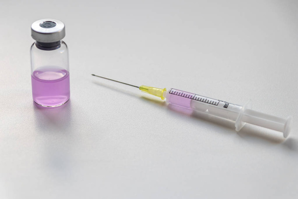 Nouveaux vaccins médicaux prêts à être testés avec une seringue et une ampoule pour injecter le remède pour l'immunisation aux patients malades et faibles afin de guérir leurs souffrances et maladies soutenues par le système de soins de santé
 - Photo, image