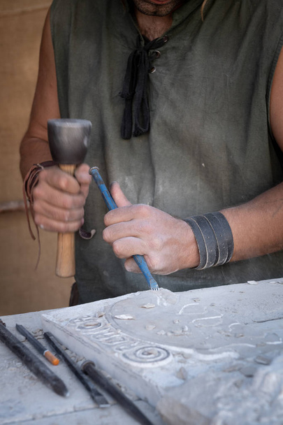 man's hands working with hammer and chisel in craft worksho - Photo, Image
