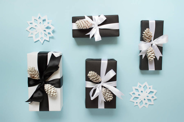 Winter arrangement of presents with pine cones and golden bow on - Foto, imagen