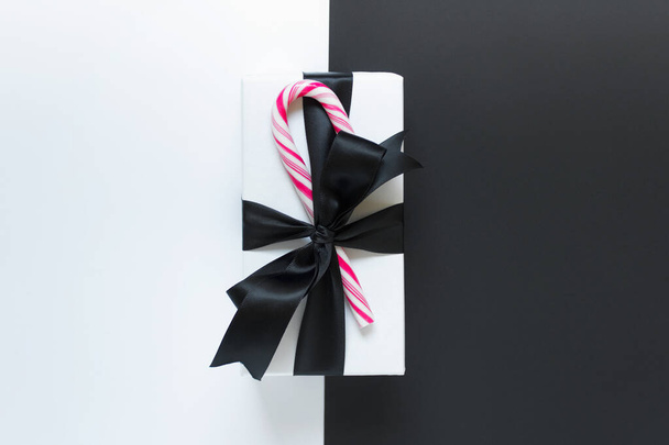 Single present with black satin bow and candy on duoble backgoun - Fotoğraf, Görsel