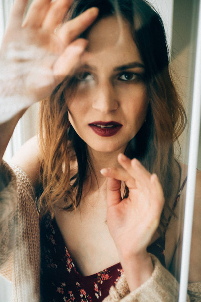 atractiva mujer con hermoso maquillaje posando detrás de vidrio
 - Foto, Imagen