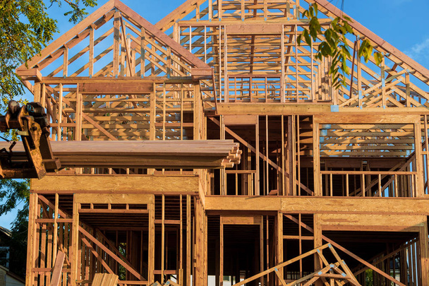 Drewniana kratownica dachu jest podnoszona przez boom wózka widłowego w dachu nowego domu - Zdjęcie, obraz