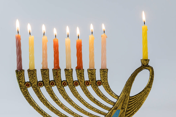 Menorah avec des bougies allumées pour célébrer Hanoukka. Une bougie symbolique allumée pour les fêtes juives
 - Photo, image