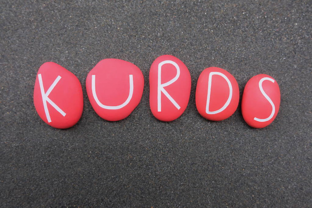 Kurden, ethnischer Gruppenname, bestehend aus roten Steinbuchstaben über schwarzem Vulkansand - Foto, Bild