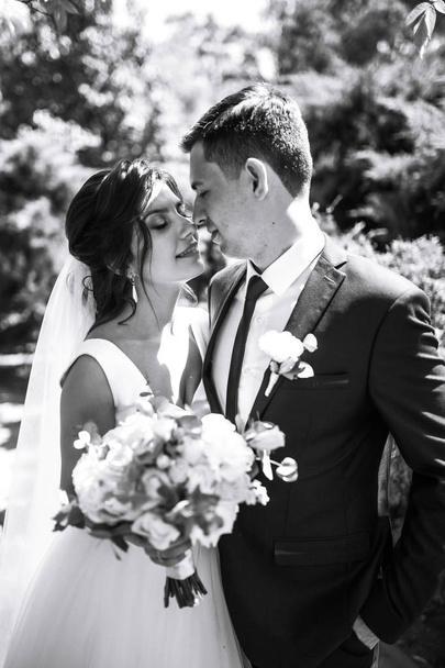 Black and white photo of cheerful emotional newlyweds who enjoy each other. Amazing smiling wedding couple. Pretty bride and stylish groom. Romantic moment.Together. Wedding. Marriage. - Φωτογραφία, εικόνα