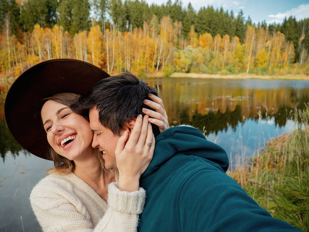 jeune couple serrant tendrement sur le lac et prendre un selfie
 - Photo, image