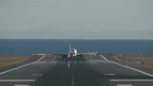 Aircraft successful landing on runway overlooking sea - Footage, Video