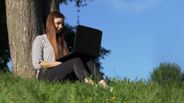 Business woman working on laptop computer at outdoor park - Felvétel, videó
