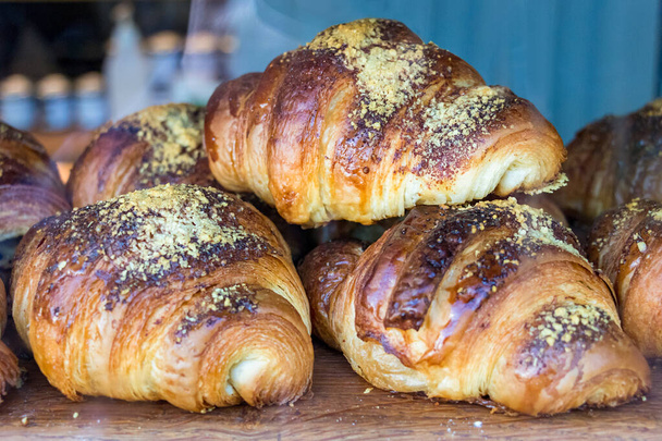 Nahaufnahme französischer Croissants, die gerade gebacken wurden, platziert auf dem Schaufenster einer Bäckerei in Island. - Foto, Bild