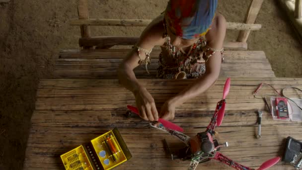 Hombre joven indígena está construyendo un dron en su cabaña rural
 - Imágenes, Vídeo