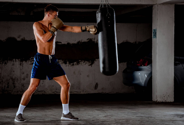 Boxeador lanza golpes en el gimnasio mientras entrena
 - Foto, Imagen