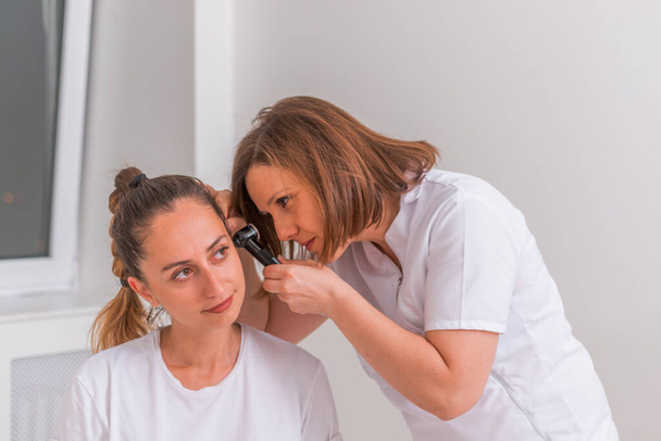 Une femme médecin effectue un examen otolaryngologique sur un mignon tee - Photo, image