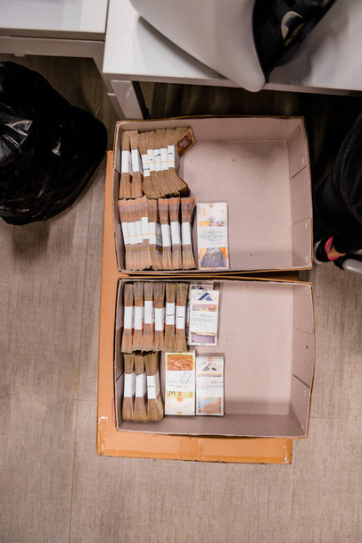 Gran cantidad de efectivo con bandas de divisas colocadas en cajas
 - Foto, Imagen