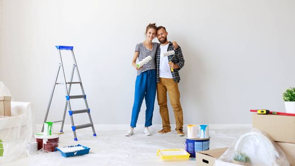 junges glückliches Paar repariert und bemalt Wand bei hom - Foto, Bild