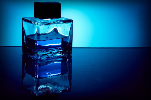 Background with bottle of perfume with blue liquid, backlit. Copy space - Valokuva, kuva