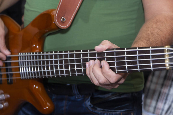 elektrická baskytara v mužských rukou, tmavé pozadí - Fotografie, Obrázek