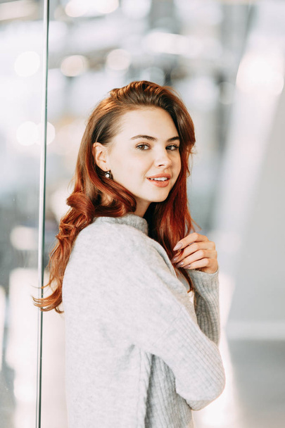 Bright emotions, smile and burning eyes of the model. Portrait of a beautiful girl in the business center.  - Zdjęcie, obraz