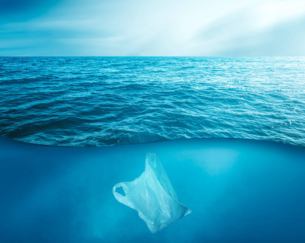 a discarded plastic rubbish bag floats underwater on a presenting a hazard to all marine life  - 写真・画像