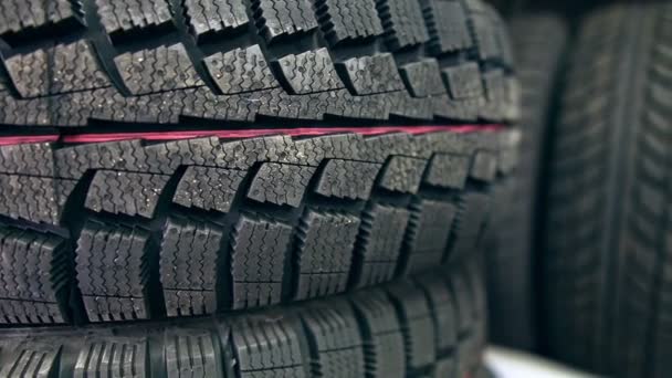 Many new winter tires on shelves and in columns. Panorama of the store - Footage, Video