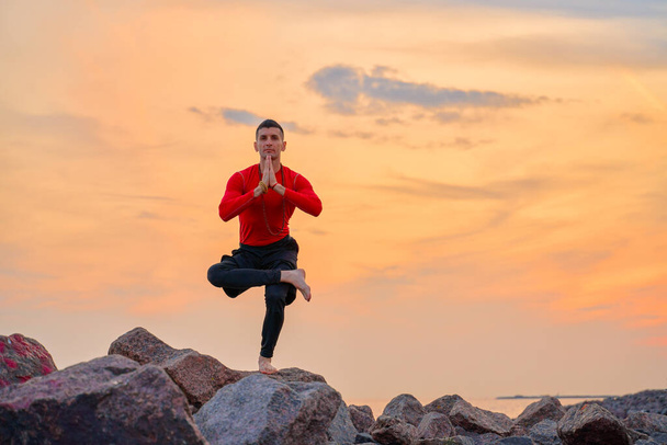 athletic man doing yoga asanas in nature, sand sea - Photo, Image