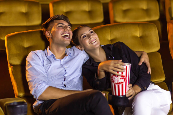 Casal assistindo filme no cinema tendo pipocas
 - Foto, Imagem