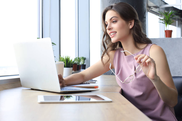 Όμορφη γυναίκα των επιχειρήσεων σε smart casual φορούν εργάζονται σε φορητό υπολογιστή στο γραφείο - Φωτογραφία, εικόνα