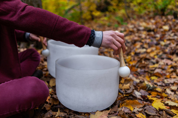 Man plays crystal bowls in the forest in the fall - Photo, Image