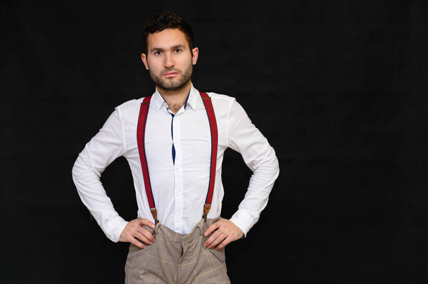 Men's fashion concept. Portrait of a handsome male model with perfect body wearing a white shirt posing on a black background. Black hair. Close Studio Shot - Φωτογραφία, εικόνα