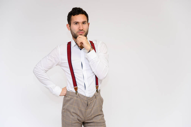 Men's fashion concept. Portrait of a handsome male model with perfect body wearing a white shirt posing on a white background. Black hair. Close Studio Shot - Φωτογραφία, εικόνα