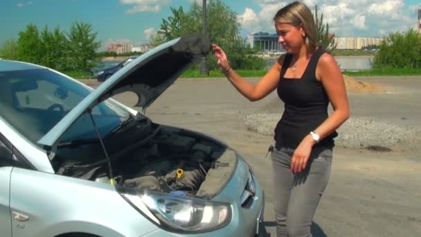 Blonde opens the hood of a car - Filmmaterial, Video