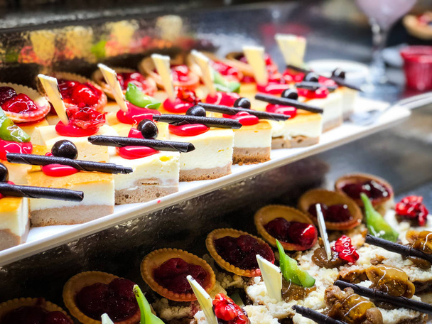 mezcla de mini pasteles y dulces con frutas frescas y cobertura acristalada
 - Foto, Imagen