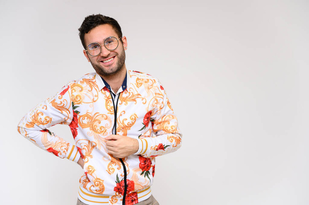 Mens fashion concept. Portrait of a handsome male model showing hands wearing a white floral jacket posing on a white background. Black hair. Close Studio Shot - Foto, imagen