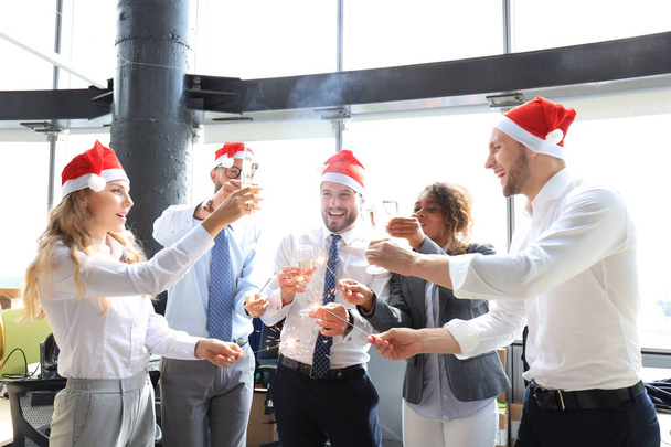 Business people are celebrating holiday in modern office drinking champagne and having fun in coworking. - Fotoğraf, Görsel