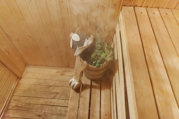 Szczegóły wnętrza sauna fińska łaźnia parowa z tradycyjną sauną akcesoria umywalka brzoza miotła miarka czuł kapelusz - Zdjęcie, obraz