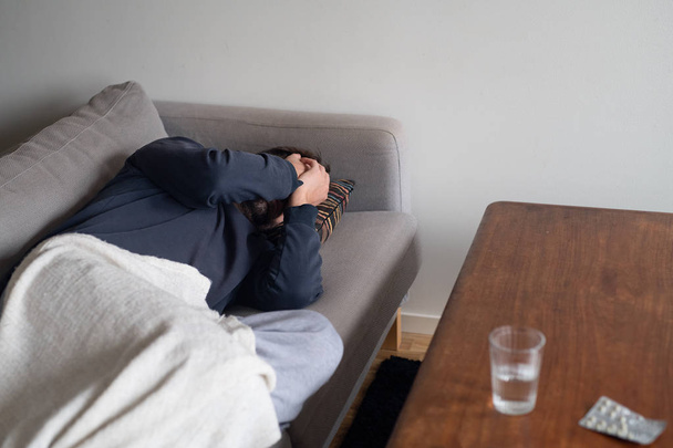 depressiver und ängstlicher Mann zu Hause auf dem Sofa - Foto, Bild