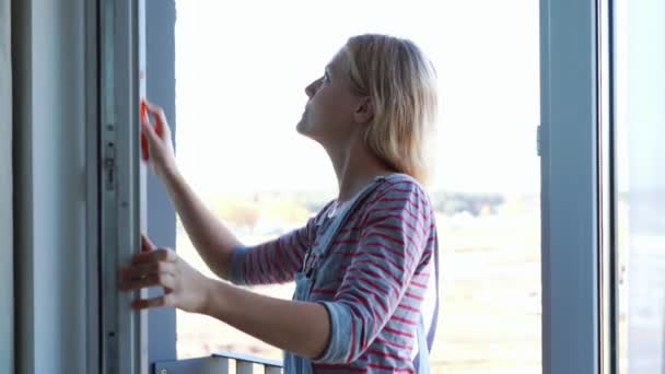 jovem mulher limpando a janela - Filmagem, Vídeo