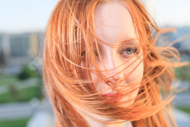 Candid closeup portrait of the young sexy redhead woman with flying hair - Φωτογραφία, εικόνα