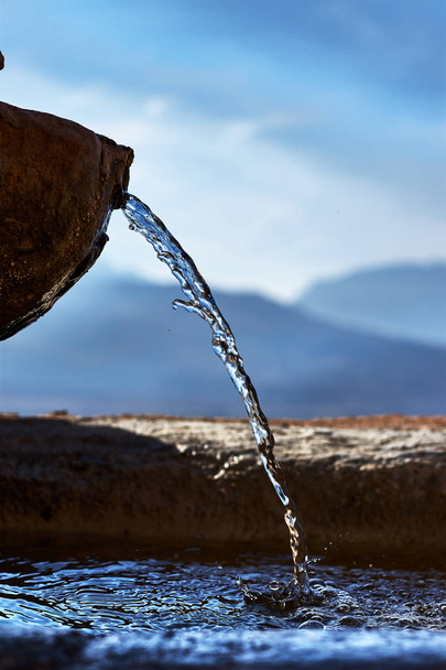 Кам'яний фонтан з прозорим і холодним водяним струменем
 - Фото, зображення