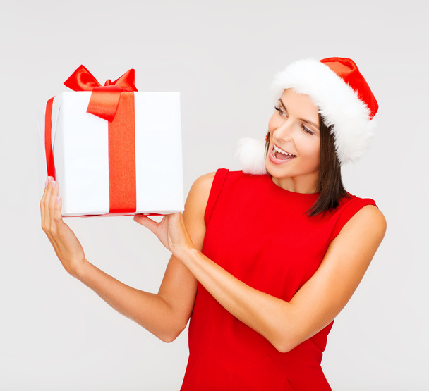 Smiling woman in santa helper hat with gift box - Фото, изображение
