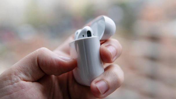Drahtlose Kopfhörer in einer weißen Hülle. moderne Soundtechnik für Musikliebhaber - Foto, Bild