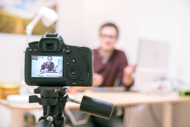 Kamera na stativu natáčení blogger doma sedí na svém pracovišti - Fotografie, Obrázek