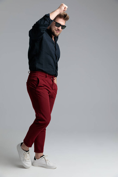 Feliz hombre de la moda celebrando con su puño en el aire
  - Foto, imagen