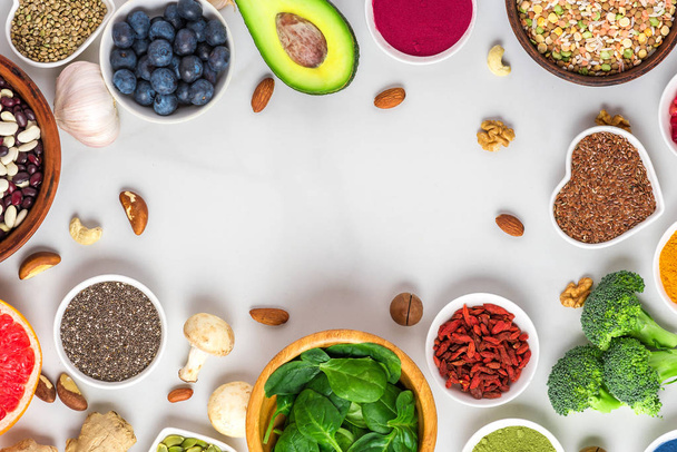 Frame made of healthy vegan food clean eating selection: fruit, vegetable, seeds, superfood, nuts, berries - Photo, Image