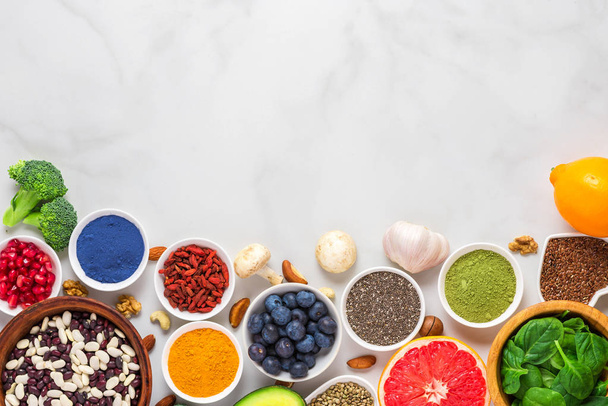 assortimento di sano cibo vegan su sfondo di marmo. verdure, matcha, acai, curcuma, frutta, frutti di bosco
 - Foto, immagini