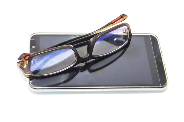 Telefoon en brillen worden gebruikt voor mensen met een visuele handicap.  - Foto, afbeelding