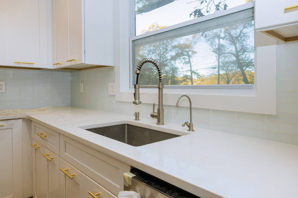 Lavello e finestra in acciaio inox centrati in una cucina
 - Foto, immagini