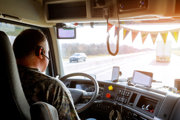 Driver in cabin of big modern truck - Photo, Image